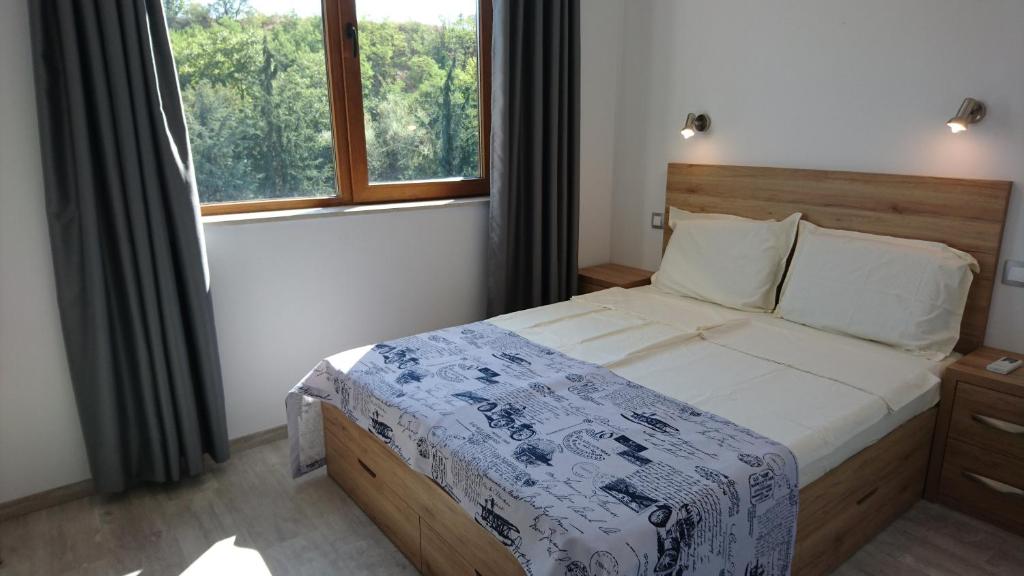 a bedroom with a large bed and a window at Park Apartments & Rooms Popovi in Sandanski