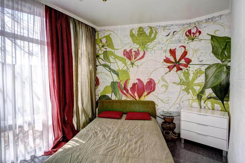 1 dormitorio con 1 cama y papel pintado con motivos florales en The Wall - уединение без ограничений, en Odessa