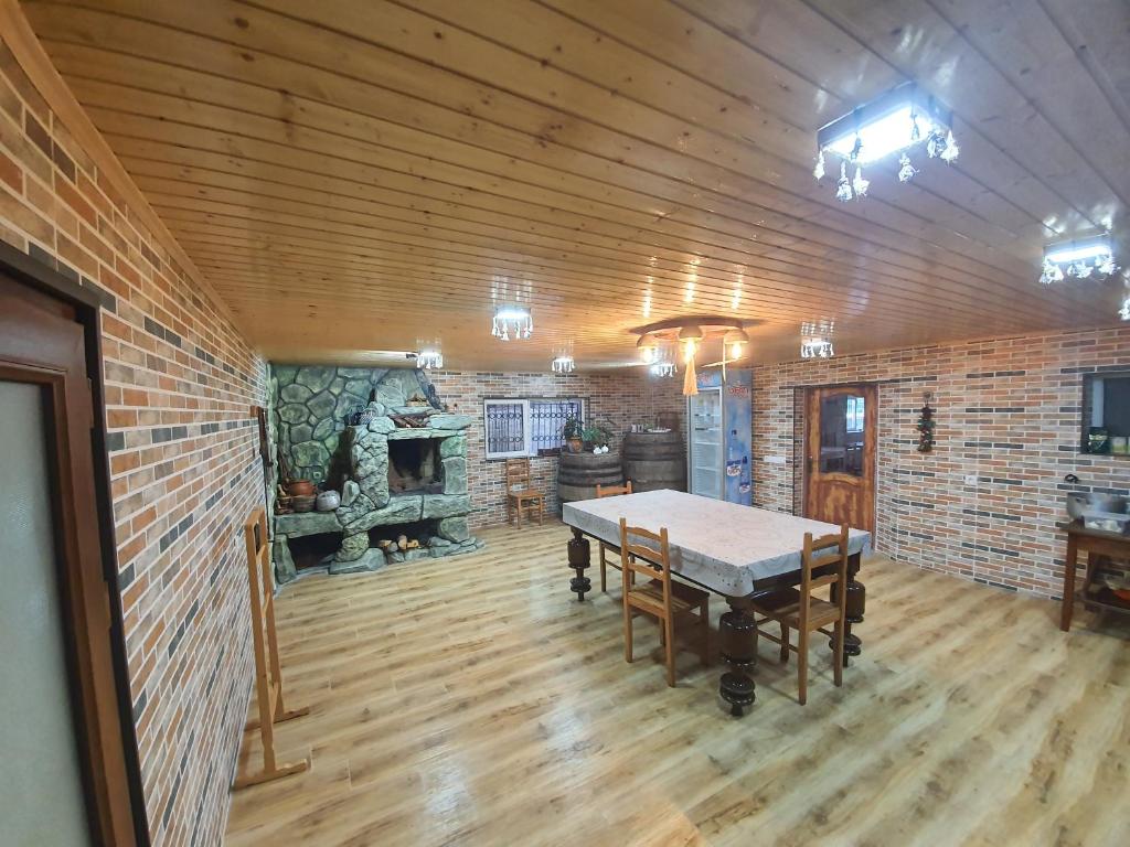 a dining room with a table and a fireplace at Guesthouse Gua in Kutaisi