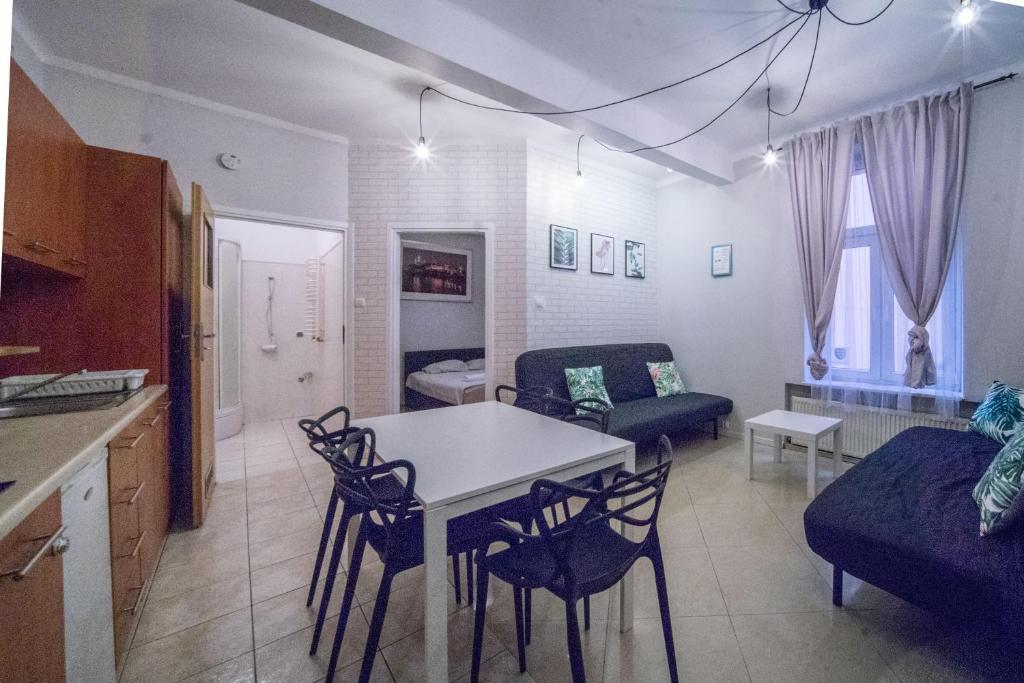 a kitchen and living room with a table and chairs at Apartament Izaaka in Krakow