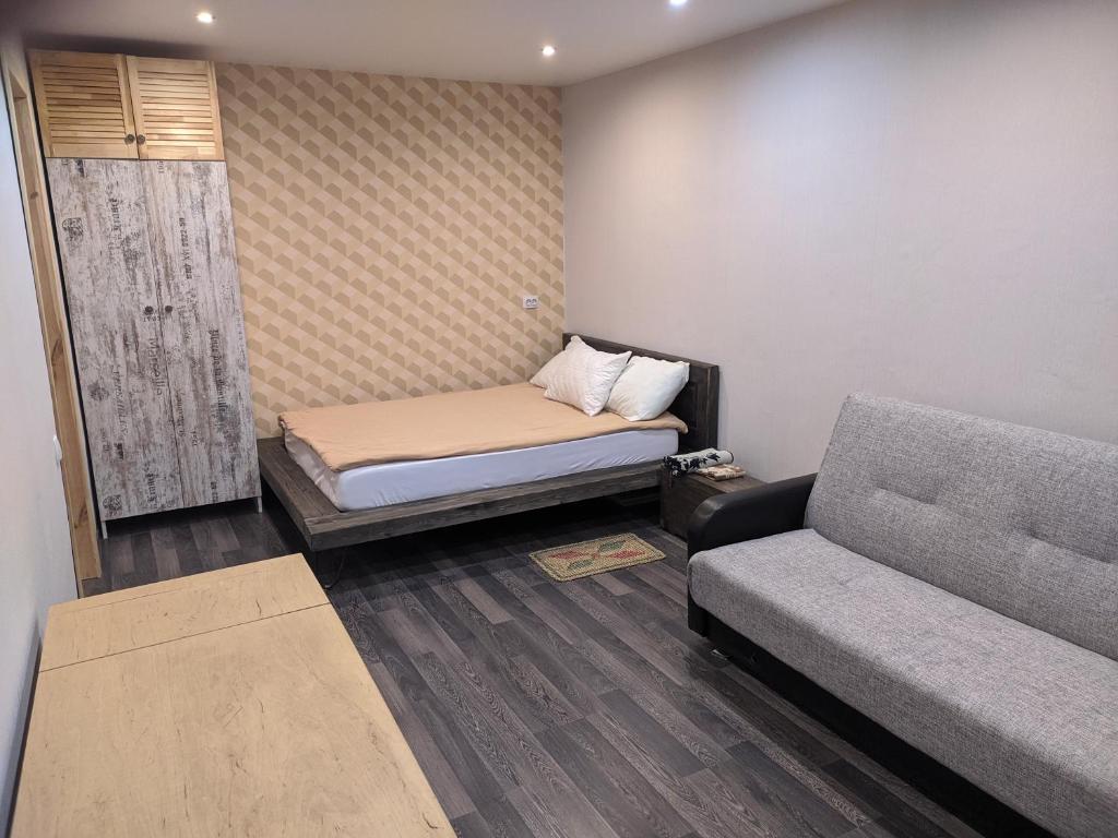 Habitación pequeña con cama y sofá en Квартира в центре Гомеля, en Gomel
