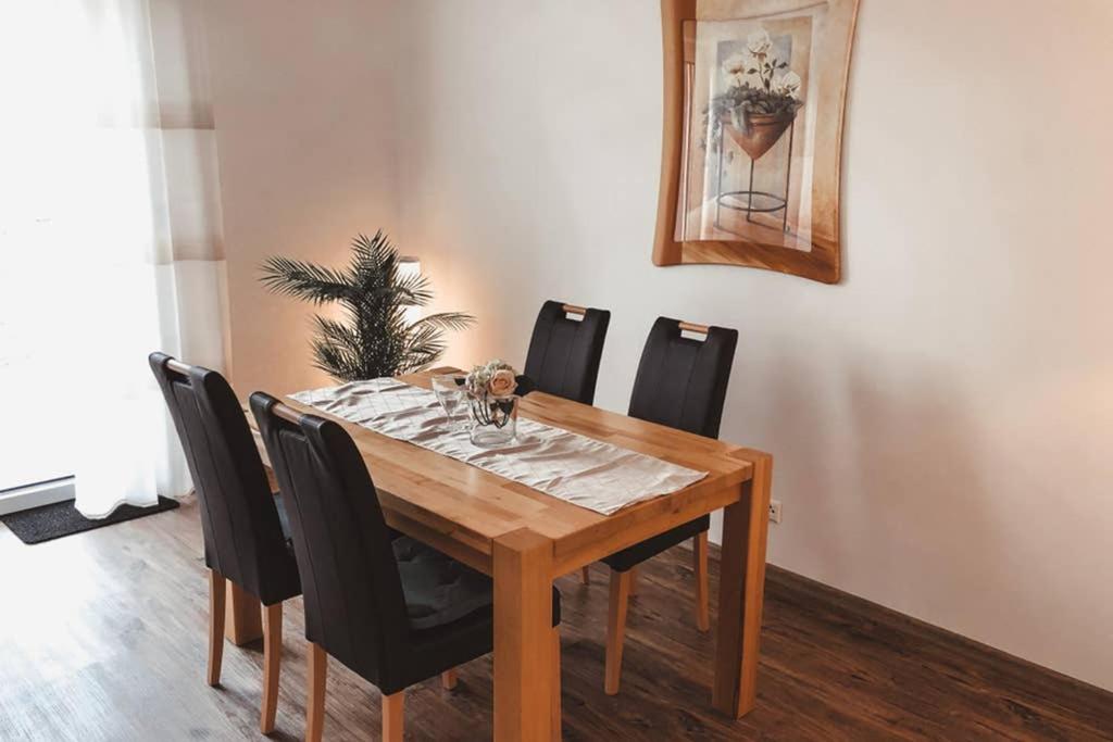 a dining room table with black chairs around it at Modernes Ferienhaus an der Kapelle in Emsbüren