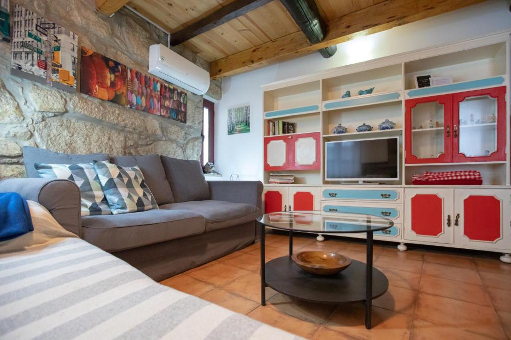 a living room with a couch and a tv at Red House- Historic center in Porto