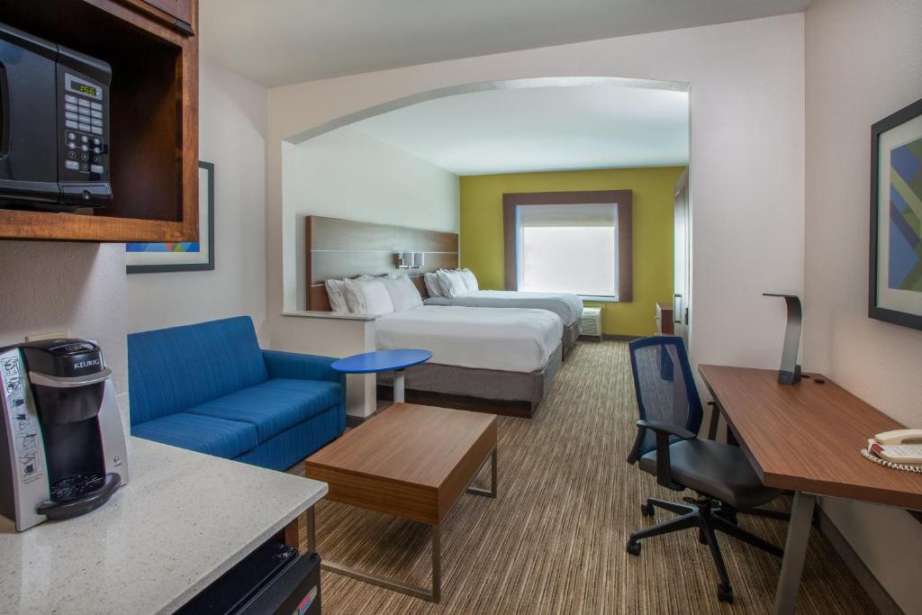 a hotel room with a bed and a living room at Holiday Inn Express & Suites Texarkana by IHG in Texarkana