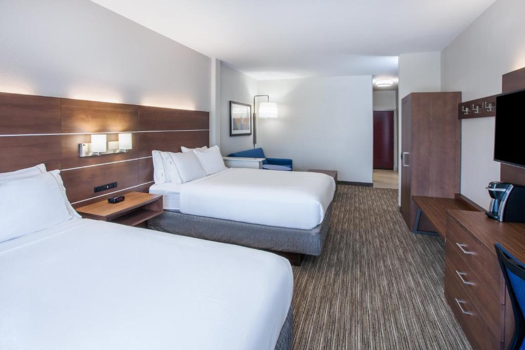 a hotel room with two beds and a flat screen tv at Holiday Inn Express & Suites Texarkana by IHG in Texarkana