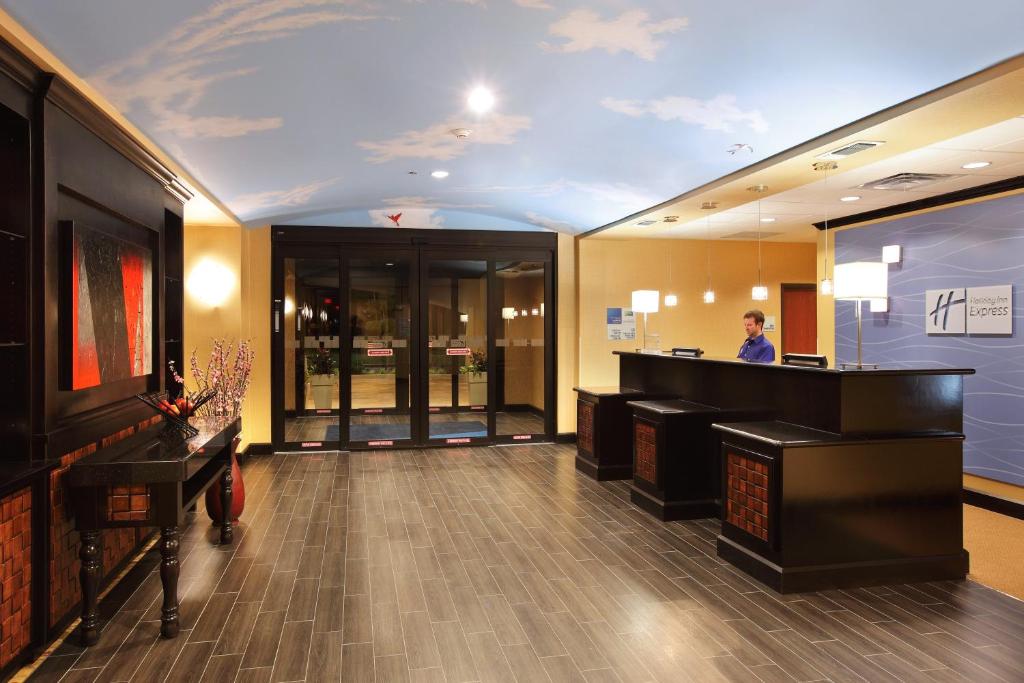 a lobby of a hotel with a woman standing at a counter at Holiday Inn Express Hotel & Suites Texarkana East by IHG in Texarkana