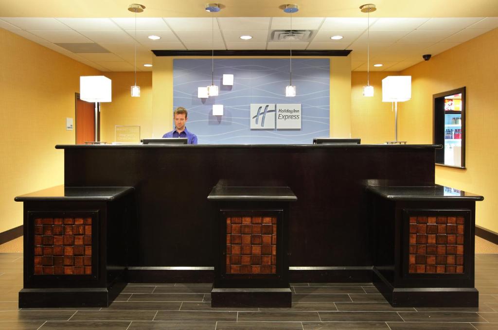 a man standing behind a bar in a lobby at Holiday Inn Express Hotel & Suites Texarkana East by IHG in Texarkana