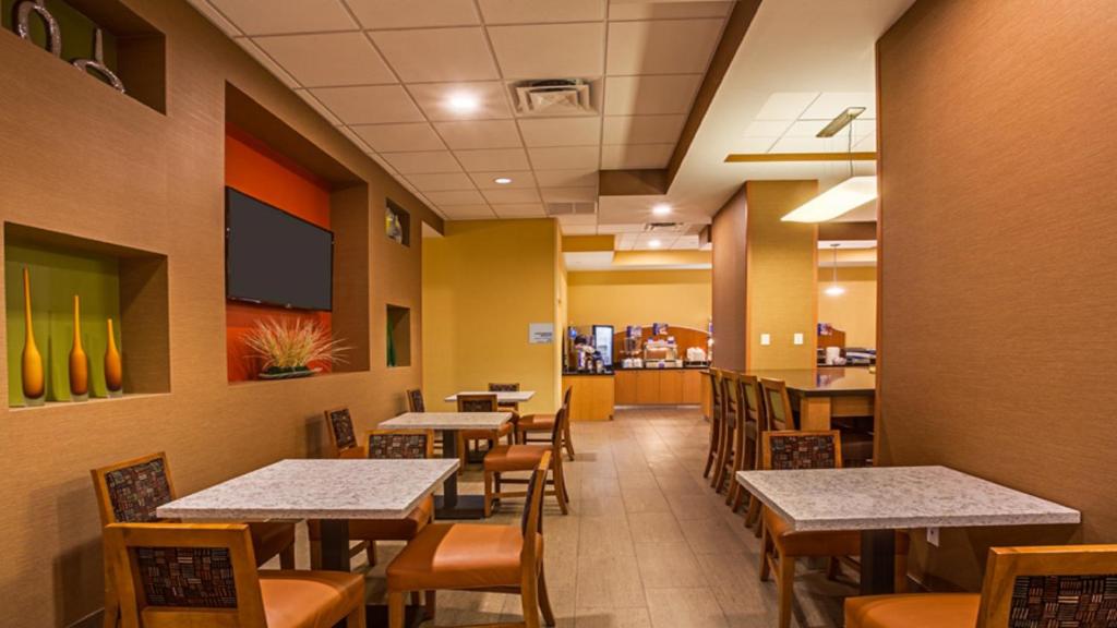 an empty dining room with tables and chairs at Holiday Inn Express Fort Lauderdale Airport South by IHG in Dania Beach