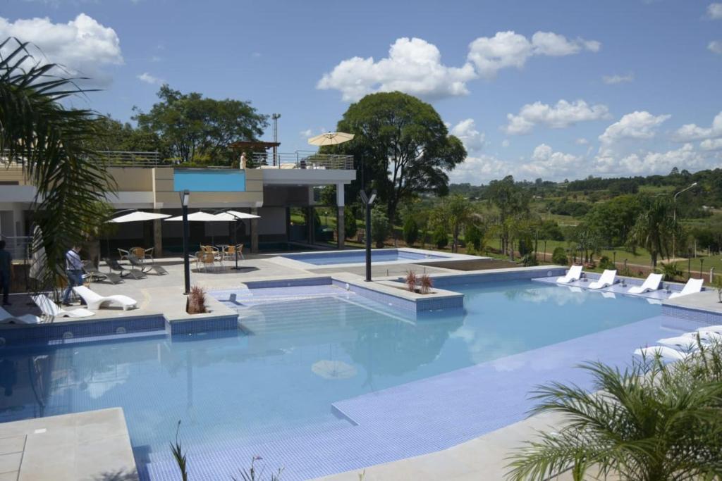 a large swimming pool with chairs and a building at Austral Hotel in Dos de Mayo