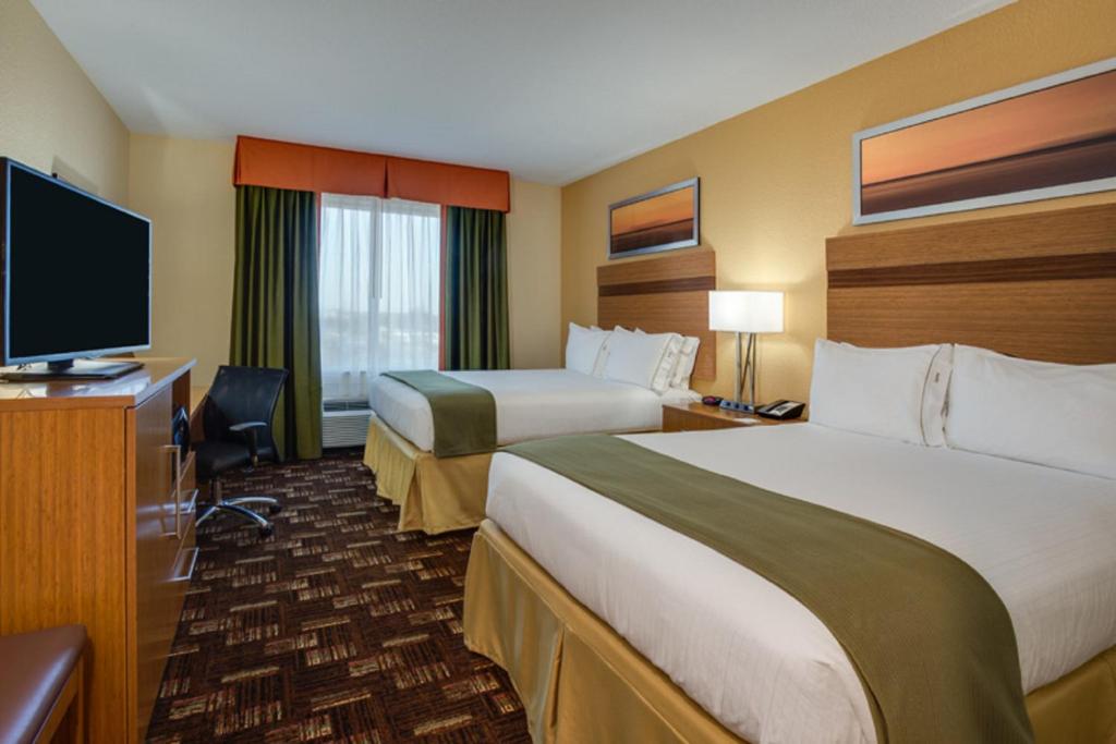 a hotel room with two beds and a flat screen tv at Holiday Inn Express Fort Lauderdale Airport South by IHG in Dania Beach