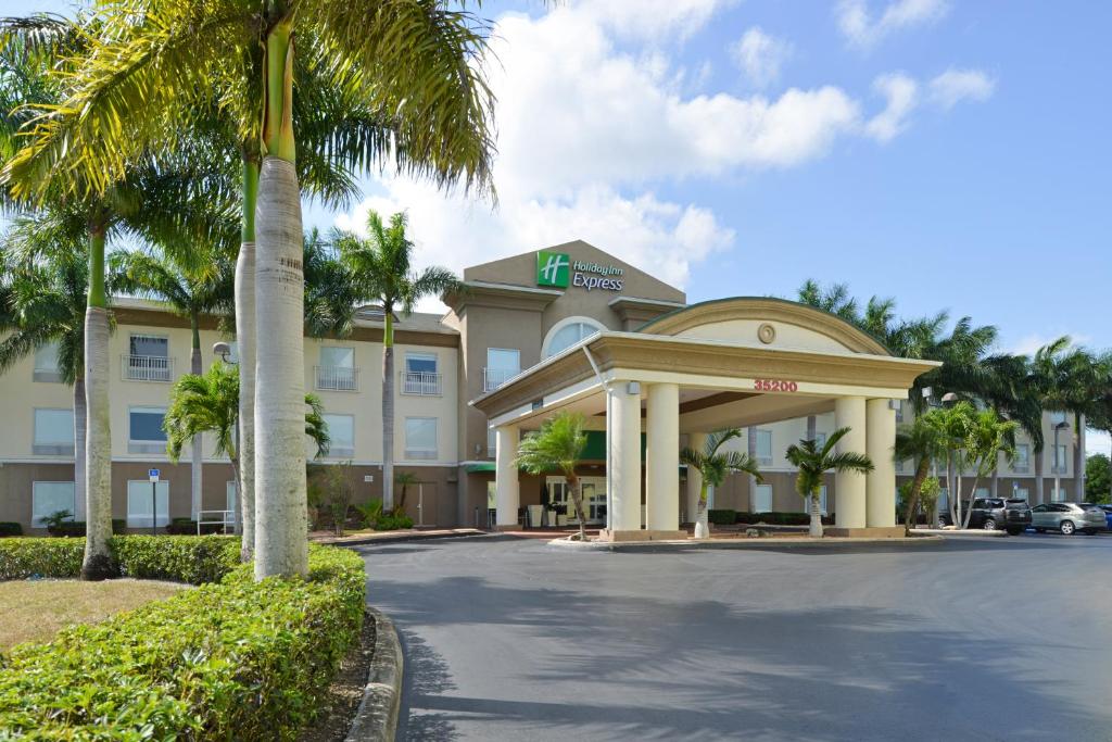 a hotel with a palm tree in front of a building at Holiday Inn Express & Suites Florida City-Gateway To Keys, an IHG Hotel in Florida City