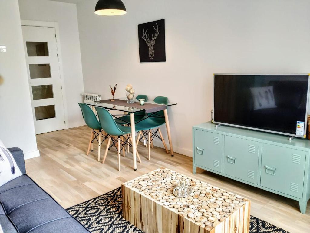 a living room with a couch and a table and a tv at apartamento La Coqueta in Santander