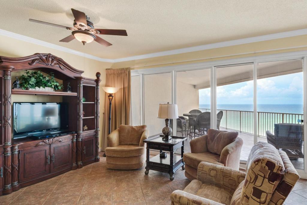 a living room with a television and a balcony at TOPS'L Tides III in Destin