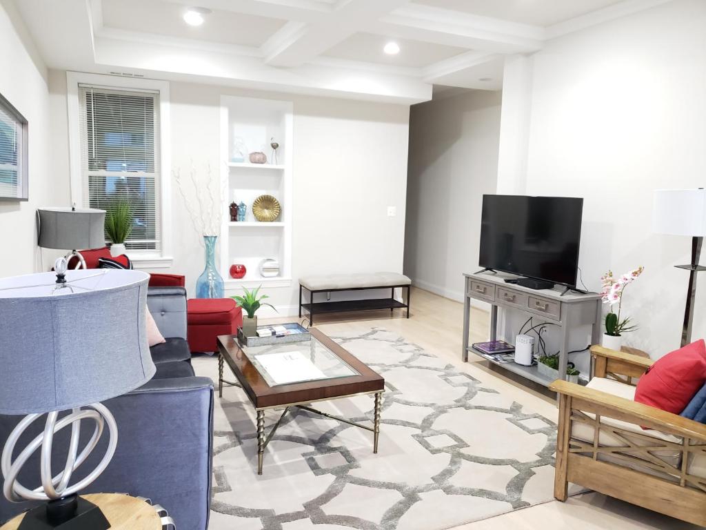 uma sala de estar cheia de mobiliário e uma televisão de ecrã plano em Spacious & Bright home In Bloomingdale/ Truxton DC em Washington