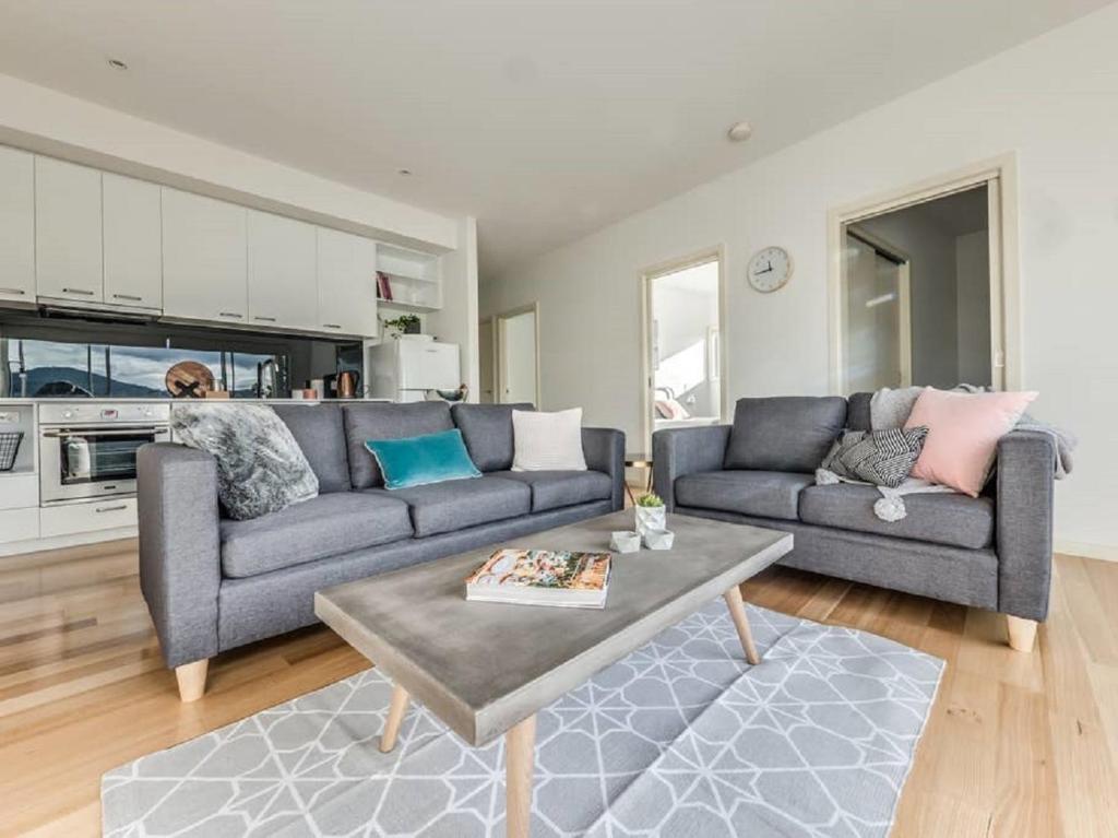 a living room with a couch and a table at Marina View Apartment in Hobart