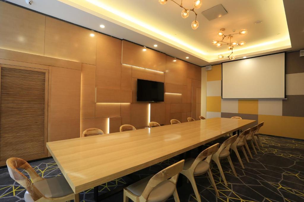 uma sala de conferências com uma grande mesa de madeira e cadeiras em Holiday Inn Express Zhangjiakou Park View, an IHG Hotel em Zhangjiakou
