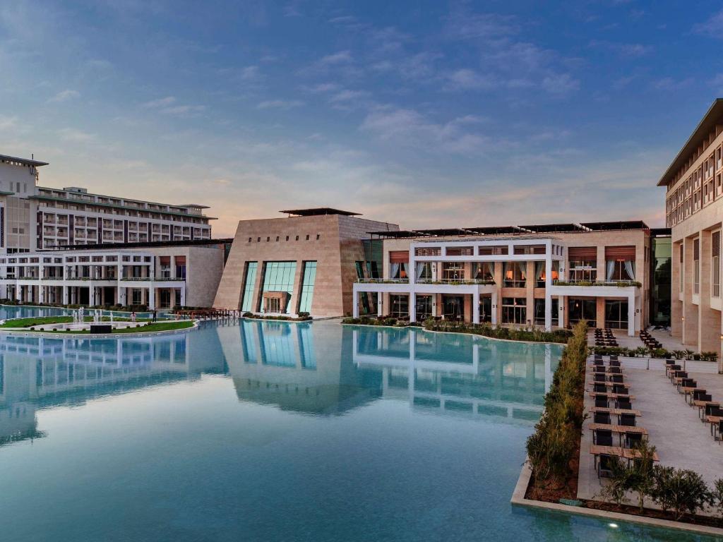 una gran piscina de agua frente a los edificios en Rixos Premium Belek - The Land of Legends Access, en Belek