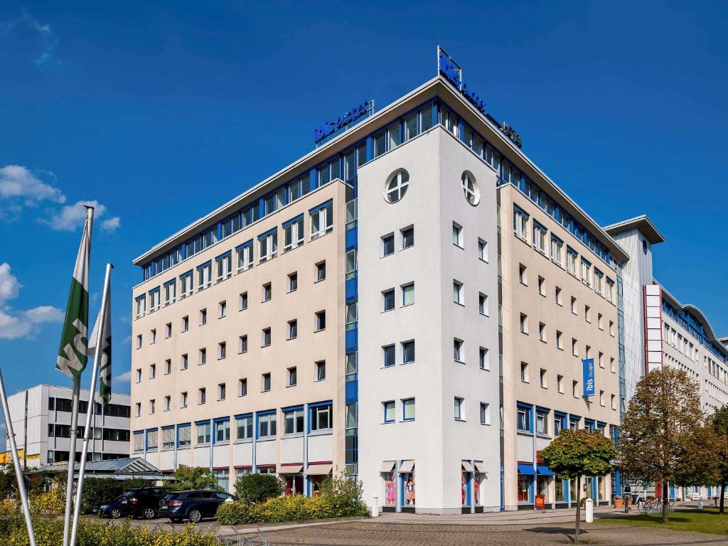 a white building with a clock on the top of it at ibis budget Berlin Ost in Berlin