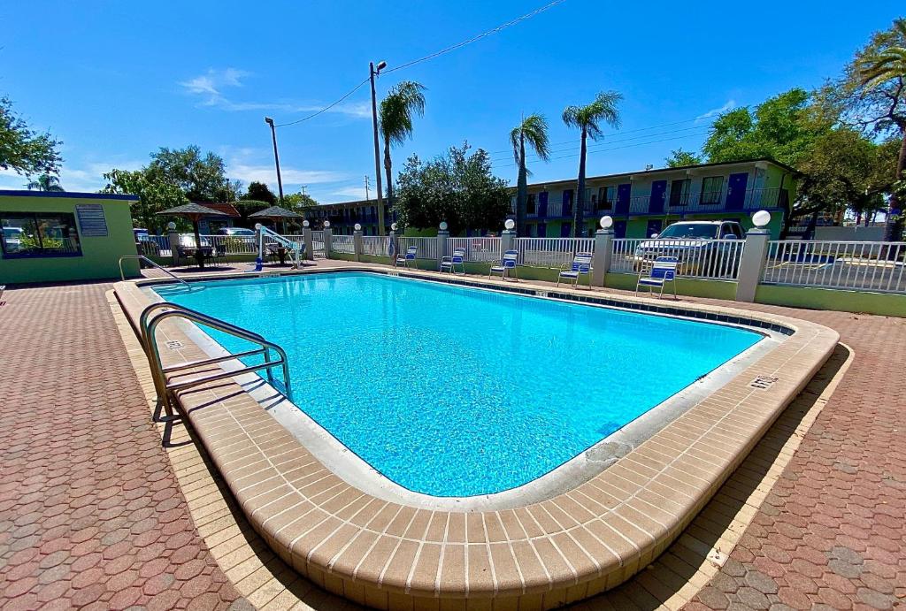 uma grande piscina com bancos à volta em Gulf Way Inn Clearwater em Clearwater