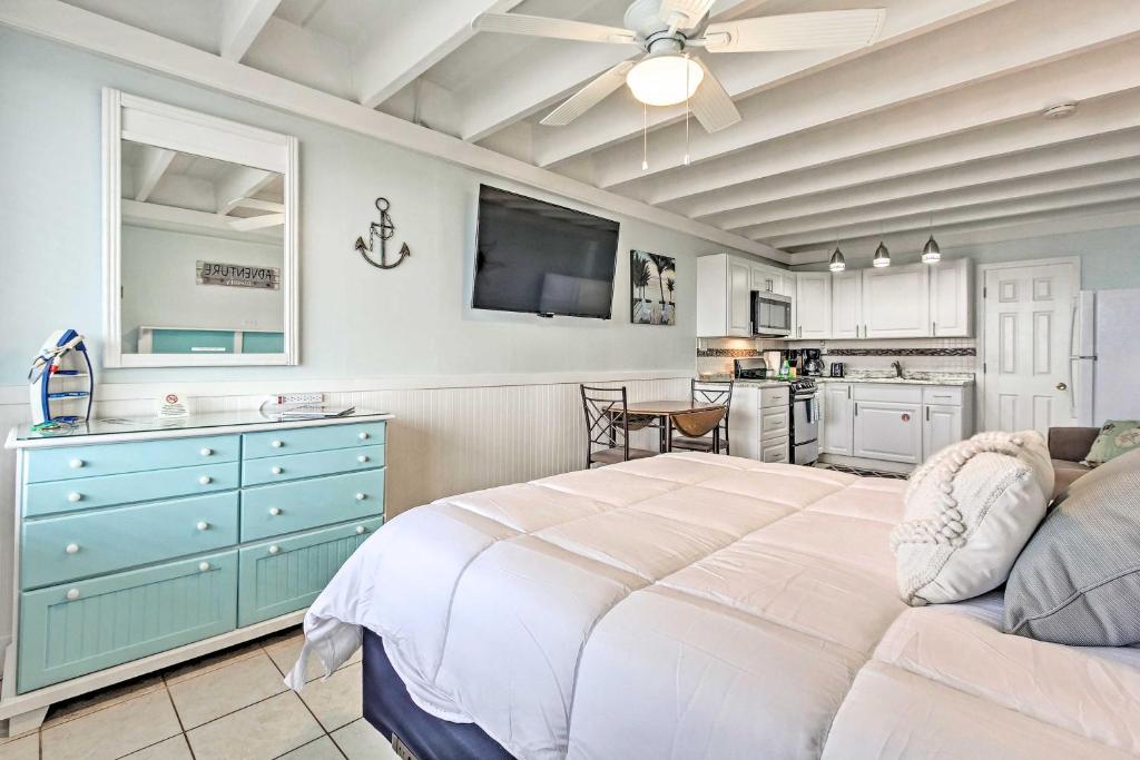 1 Schlafzimmer mit einem großen weißen Bett und einer Küche in der Unterkunft Panama City Beach Studio with Pool and Beach Access in Panama City Beach