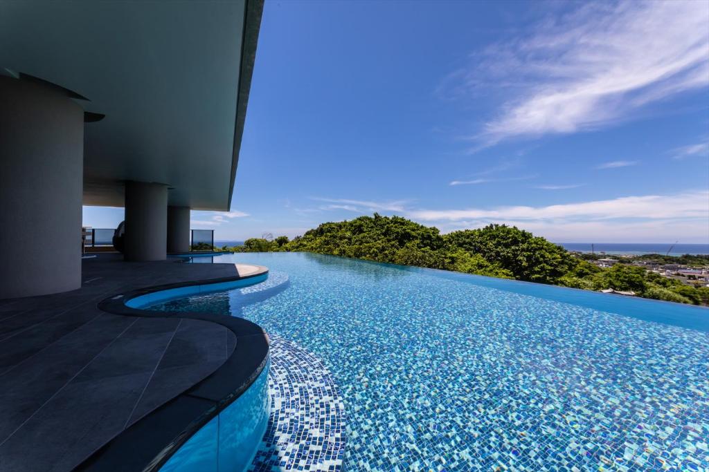 uma piscina de beiral infinito com vista para o oceano em Glamday Style Okinawa Yomitan Hotel & Resort em Yomitan