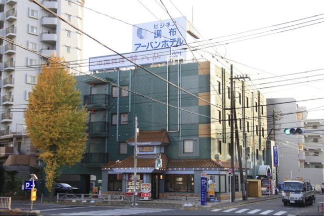 a building with a sign on the side of it at Chofu Urban Hotel in Chofu