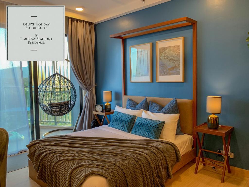 Kampung Sungai Karang的住宿－Deluxe Holiday Studio Suite at Timurbay with Seaview，一间卧室配有一张蓝色墙壁的床和一扇窗户