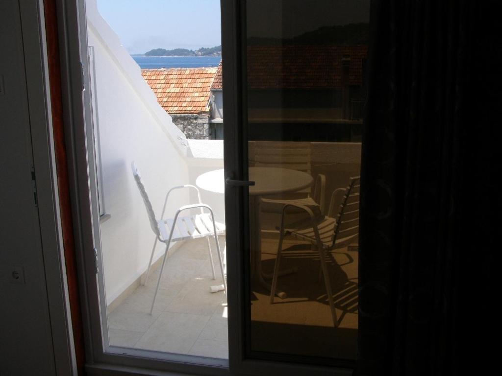 Habitación con vistas a un balcón con mesa y sillas. en Apartment Niks - terrace & sea view, en Vela Luka