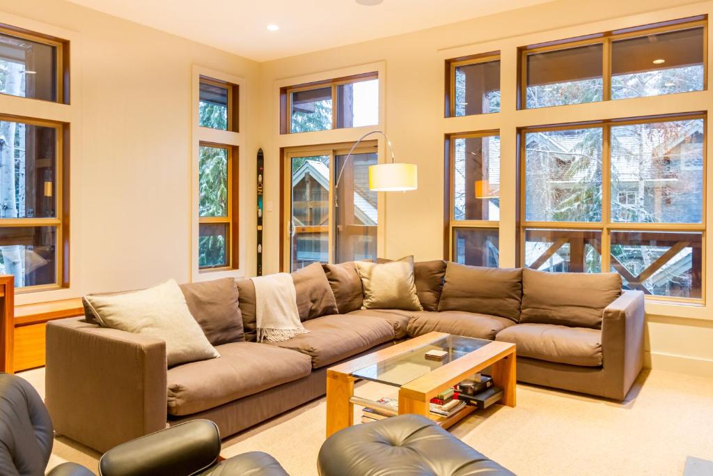 a living room with a brown couch and windows at 05 Forest Creek in Whistler