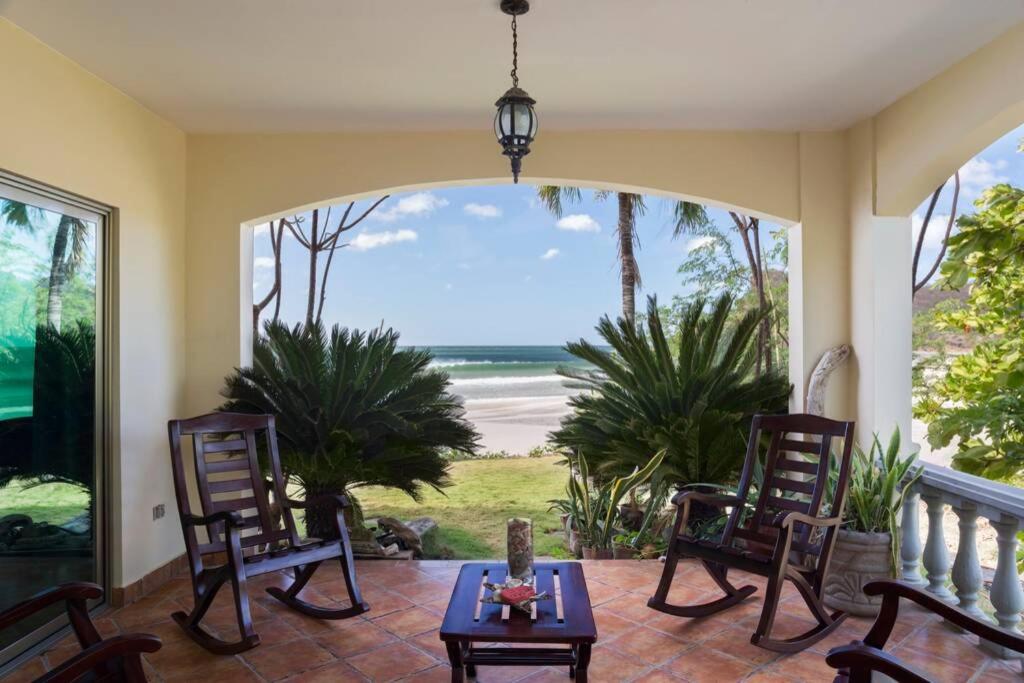weranda z krzesłami i stołem oraz widokiem na plażę w obiekcie Villas Iguana A-2 Beachfront Condo w mieście Rivas