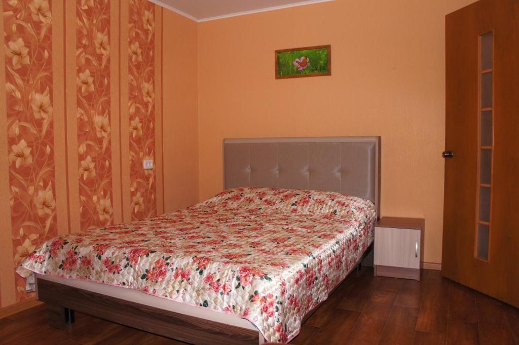トムスクにある1комнатная до 4 чел на Железнодорожной 1のベッドルーム1室(花柄のベッドカバー付)