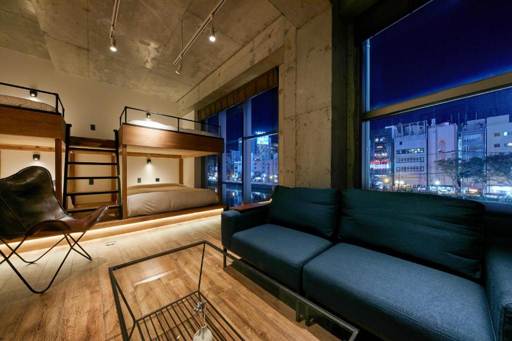 a living room with a couch and a bed at mizuka Nakasu 5 - unmanned hotel - in Fukuoka