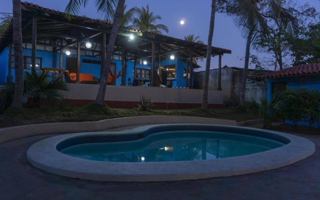 a pool in front of a house at night at Casa Garrobo in Los Cóbanos