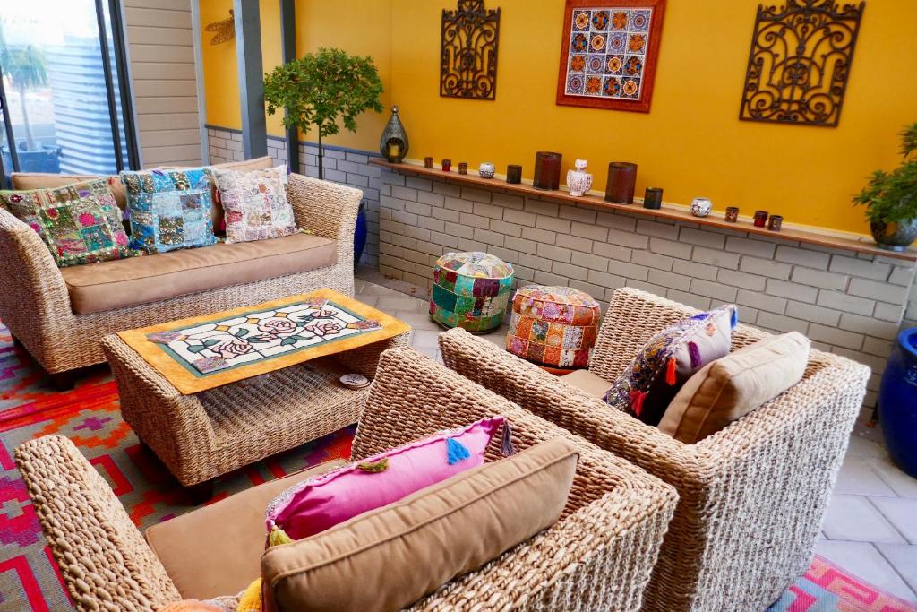 una sala de estar con sillas de mimbre y sofás en Mullaloo B & B en Perth