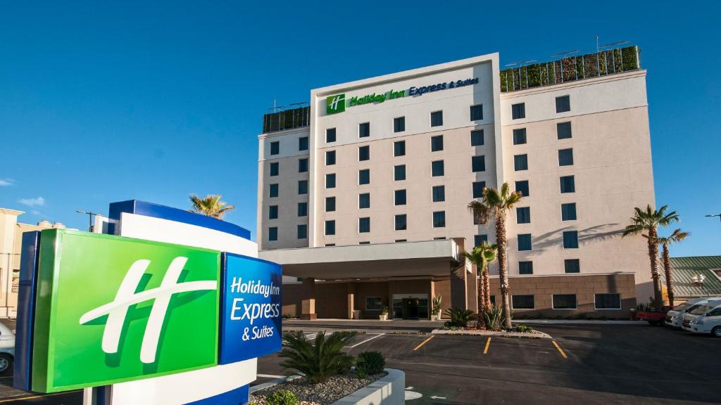 un bâtiment d'hôtel avec un panneau devant lui dans l'établissement Holiday Inn Express & Suites Chihuahua Juventud, an IHG Hotel, à Chihuahua