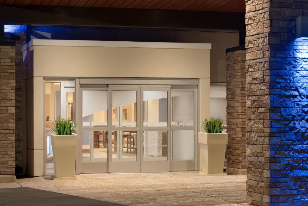 an entrance to a building with two potted plants at Holiday Inn Express & Suites - Cincinnati South - Wilder, an IHG Hotel in Wilder