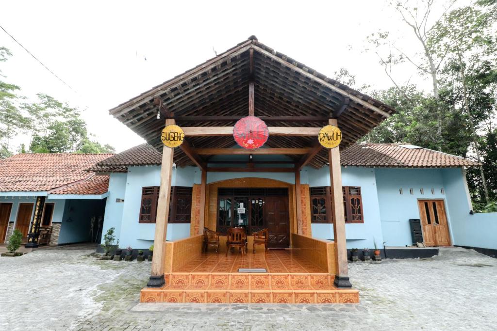 ein blaues Haus mit einem roten chinesischen Schild drauf in der Unterkunft Willy Homestay Borobudur in Borobudur