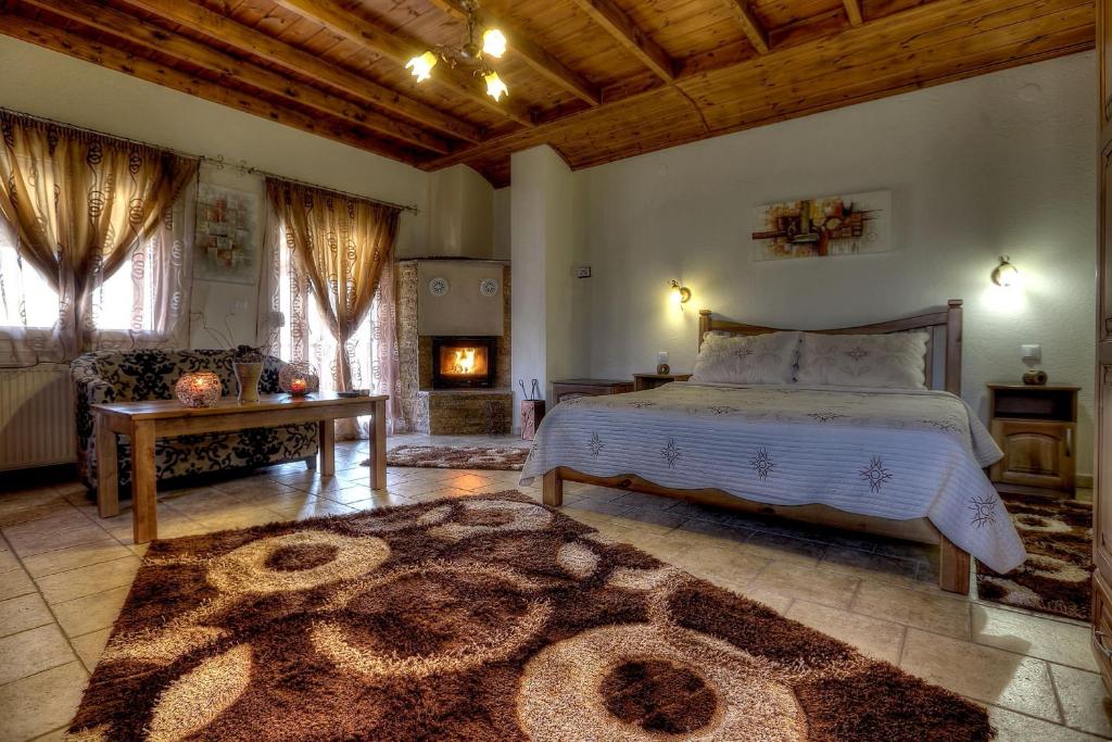 a bedroom with a large bed and a fireplace at Toula Rooms in Angistron