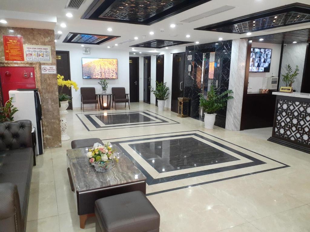 a lobby of a building with a table and chairs at T&M Luxury Hotel Hanoi in Hanoi