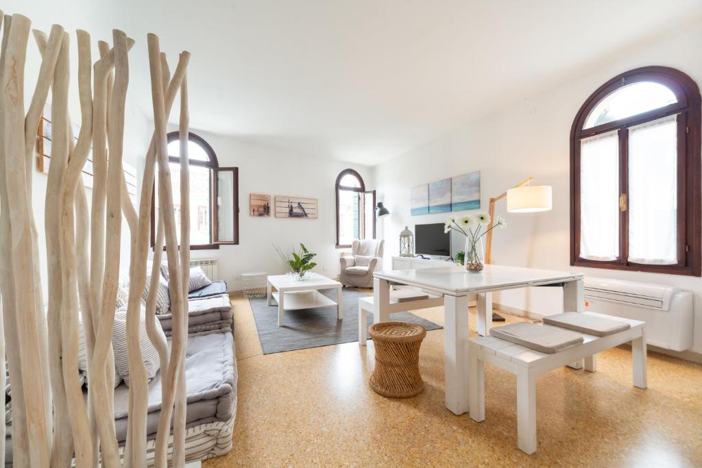 una sala de estar blanca con mesa blanca y sillas en TABACCHI446 en Venecia