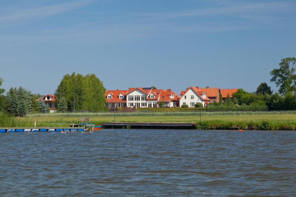 a large body of water with houses in the background at Pensjonat nad Płaskim in Jerzwałd