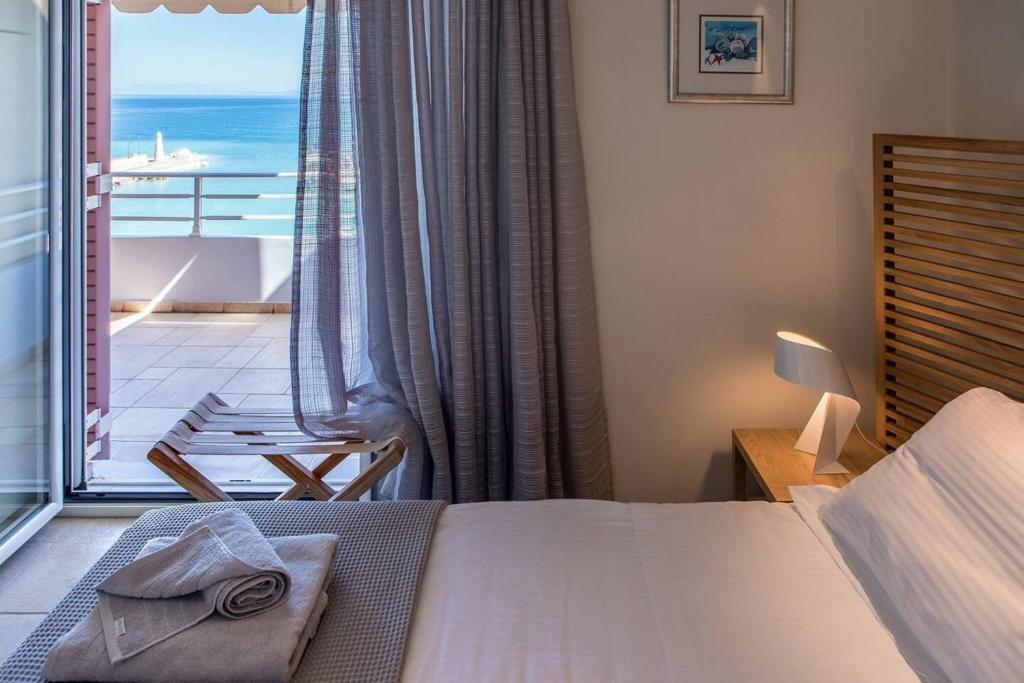 sypialnia z łóżkiem i balkonem z widokiem na ocean w obiekcie Marina View Sea Front Apartment w mieście Xylokastron
