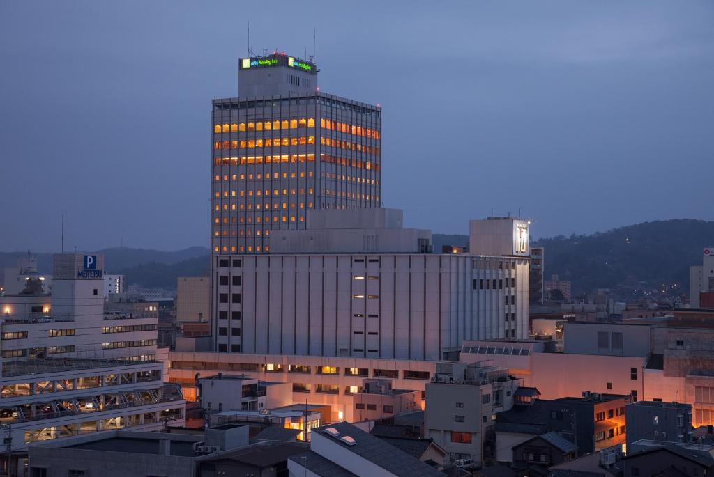 a tall building with lights on it in a city at ANA Holiday Inn Kanazawa Sky, an IHG Hotel in Kanazawa