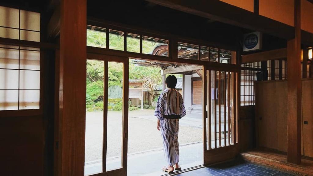 Una donna in piedi sulla porta di un palazzo di Chikurinin Gunpoen a Yoshino