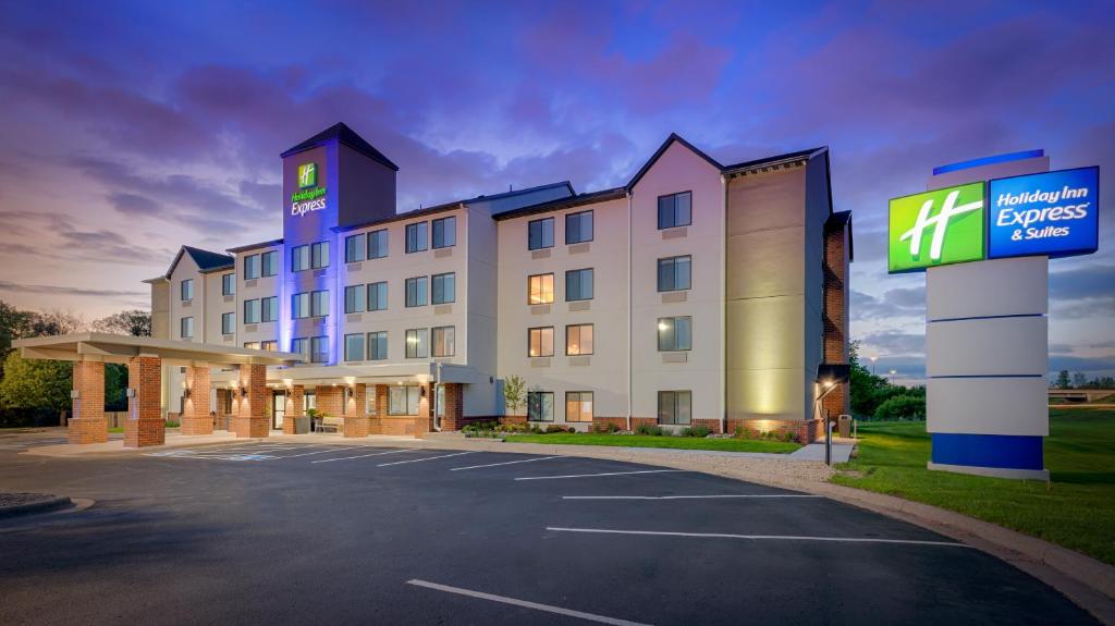 un hôtel avec un panneau dans un parking dans l'établissement Holiday Inn Express Hotel & Suites Coon Rapids - Blaine Area, an IHG Hotel, à Coon Rapids