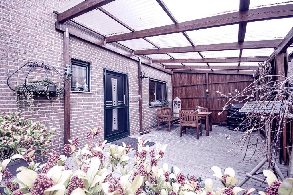 un patio con una pérgola de madera y una mesa en Ferienwohnung Leon, en Heinsberg