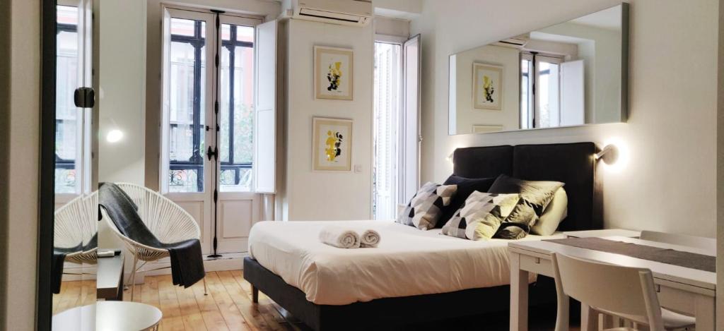 - une chambre avec un lit, une table et des chaises dans l'établissement LEEWAYS LOFT in FUENCARRAL, à Madrid