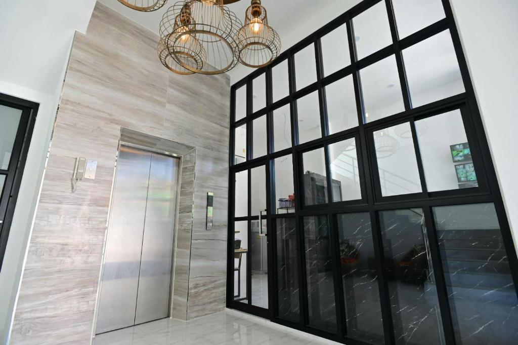 バンコクにあるParvena Ratchadaの大きなガラスドアとシャンデリアが備わる客室です。