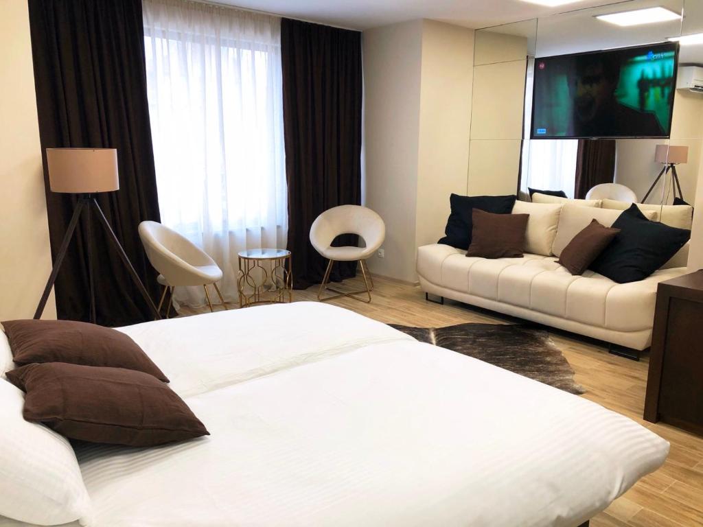 1 dormitorio con cama blanca y sofá en апартамент Мишел (Mishel), en Samokov