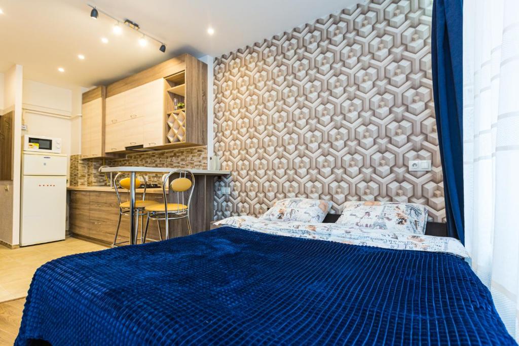 um quarto com uma cama azul em frente a uma parede em 2 Kn. Romana Apartment em Lviv